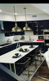 a kitchen with black cabinets and gold accents