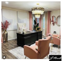 a home office with pink furniture and a chandelier
