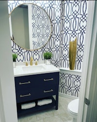 a bathroom with blue and gold wallpaper