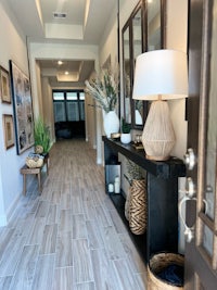 a hallway in a home with wood flooring and a lamp