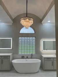 a bathroom with a large tub and a chandelier