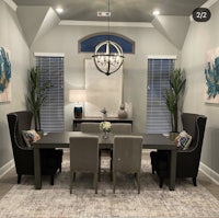 a dining room with a gray table and chairs