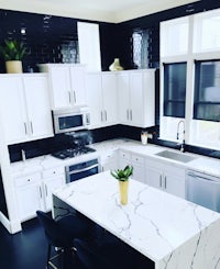 a black and white kitchen with marble counter tops