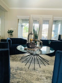 a living room with blue couches and a glass coffee table