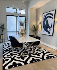 a modern dining room with a black and white rug
