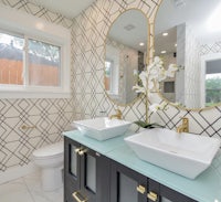 a bathroom with a black and white tiled wall