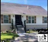 the front of a home with brown shutters and a front door