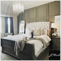 a bedroom with a king size bed and a chandelier