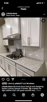a picture of a kitchen with white cabinets and granite counter tops