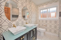 a bathroom with a black and white tiled wall