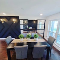 a dining room with a black table and chairs