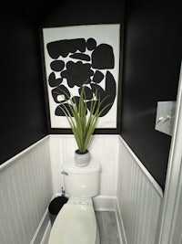 a black and white bathroom with a potted plant