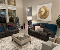 a living room with couches and a christmas tree