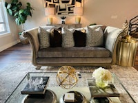 a living room with a gray couch and gold accents