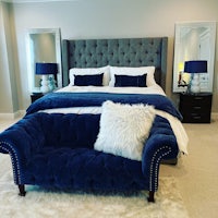 a bedroom with a bed and a blue velvet couch